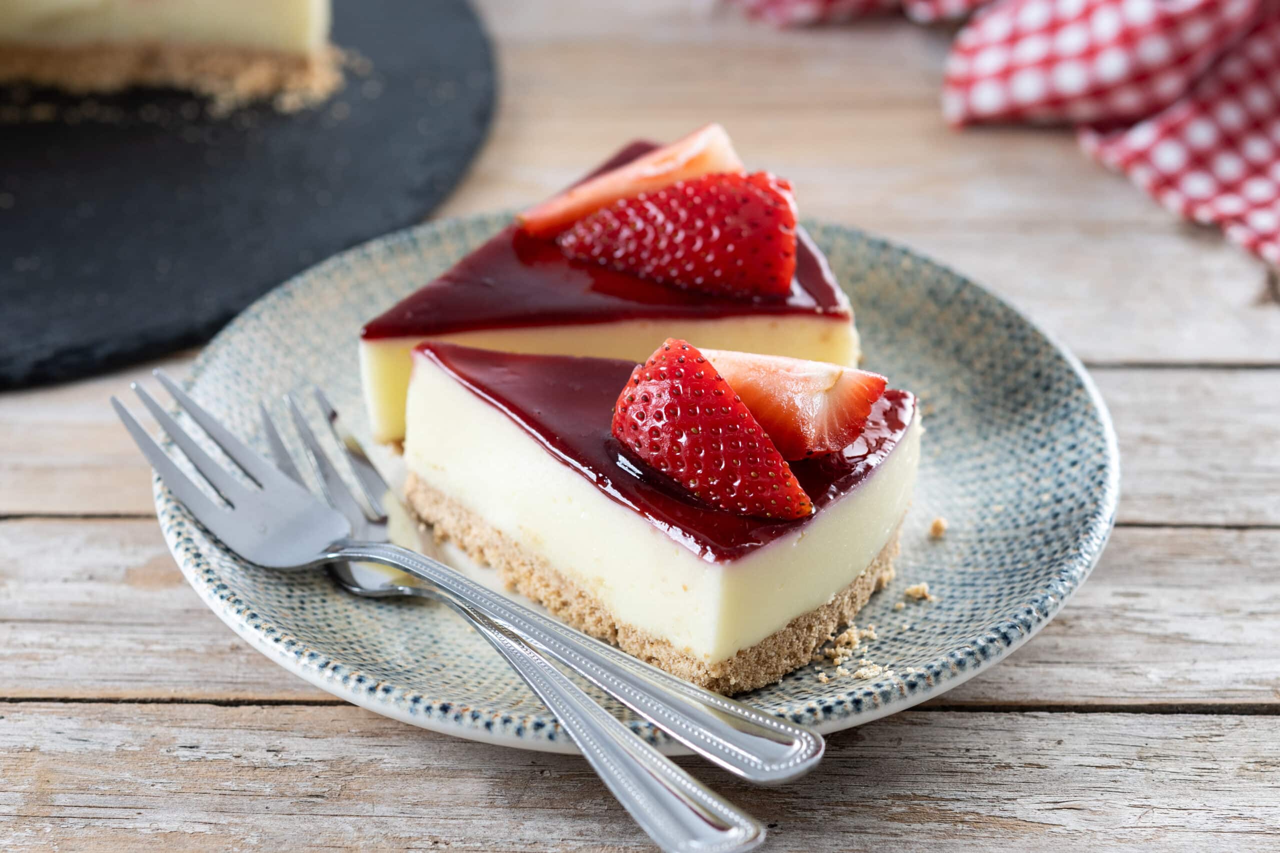 slice of cheesecake with strawberries on wooden table